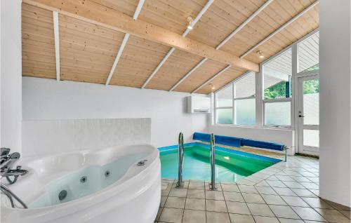 La salle de bains est pourvue d'une baignoire et d'une piscine. dans l'établissement Amazing Home In Juelsminde With Indoor Swimming Pool, à Sønderby
