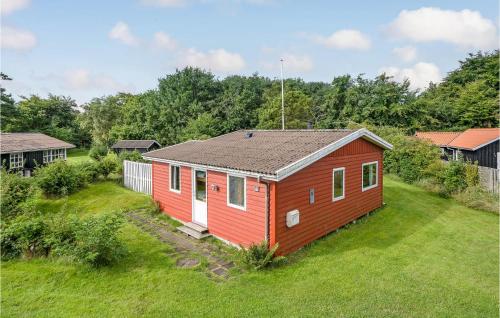 a red and white house in a field of grass at Holiday Home Bindslev 10 in Bindslev