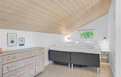 FemmøllerにあるStunning Home In Ebeltoft With 4 Bedrooms, Sauna And Wifiの木製の天井が特徴のベッドルーム1室(ベッド1台付)