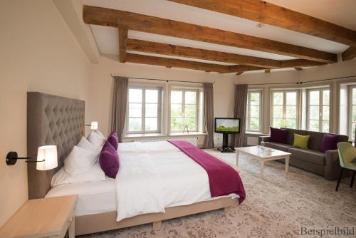 a bedroom with a large bed and a couch at Traditionshaus by Zollenspieker Fährhaus in Hamburg