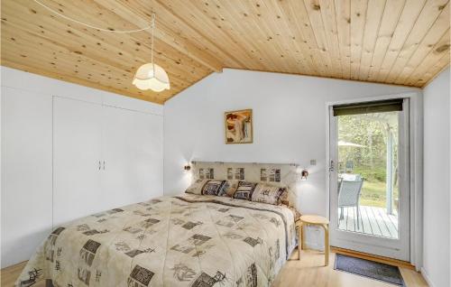 3 Bedroom Stunning Home In Hadsund في Hadsund: غرفة نوم بسرير وسقف خشبي