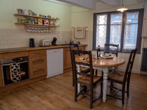 een keuken met een tafel en een tafel en stoelen bij Chez Dizjon, A Stunning Canalside Property in Josselin