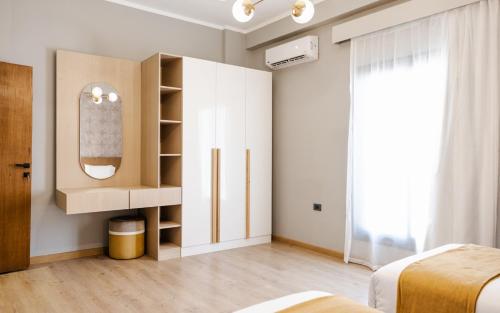 a bedroom with white cabinets and a mirror at Boutique Nest in New Cairo in Cairo