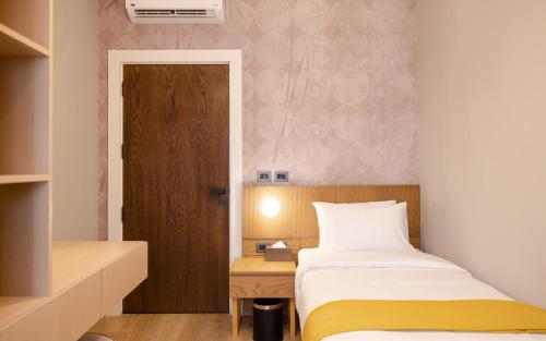 a small bedroom with a bed and a wooden door at Boutique Nest in New Cairo in Cairo