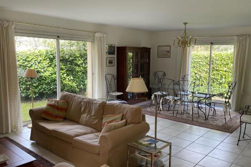 un salon avec un canapé et une table dans l'établissement Duplex house with private pool near the sea, à Lanton