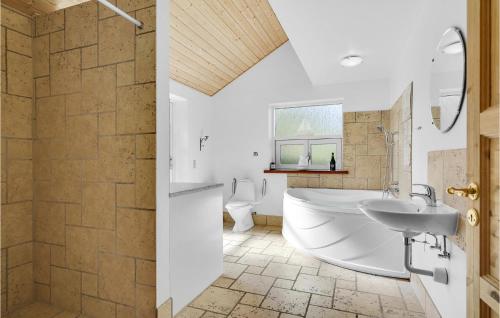 een badkamer met een bad, een toilet en een wastafel bij 5 Bedroom Cozy Home In Hadsund in Helberskov