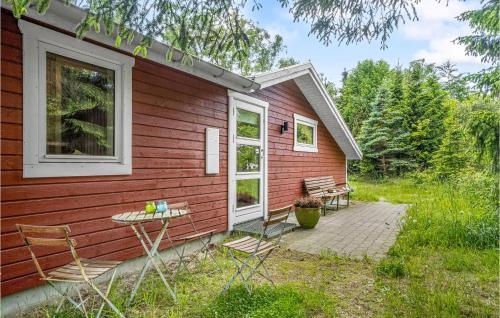 a red house with a table and chairs outside at Holiday Home Rorvig With Hot Tub Iii in Rørvig