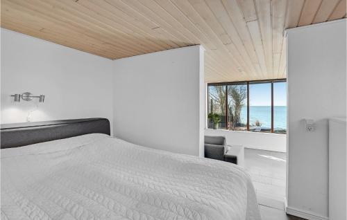 a bedroom with a bed and a view of the ocean at Beach Front Home In Vggerlse With House Sea View in Væggerløse