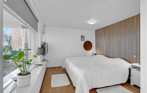 a bedroom with a white bed and a window at 4 Bedroom Lovely Home In Væggerløse in Væggerløse