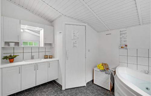 Baño blanco con bañera y lavamanos en Stunning Home In Blvand With Wifi, en Blåvand