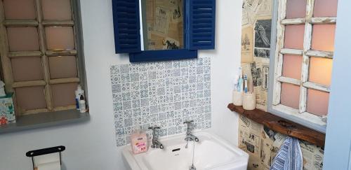 ein Bad mit einem Waschbecken und einem Spiegel in der Unterkunft La Cheneraie, A Peaceful, Rural Retreat in Ménéac