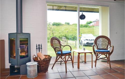 a porch with two chairs and a table and a stove at Holiday Home Lyngvej Fanø X in Fanø