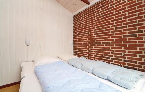 a bed in a room with a brick wall at Holiday Home Lyngvej Fanø X in Fanø