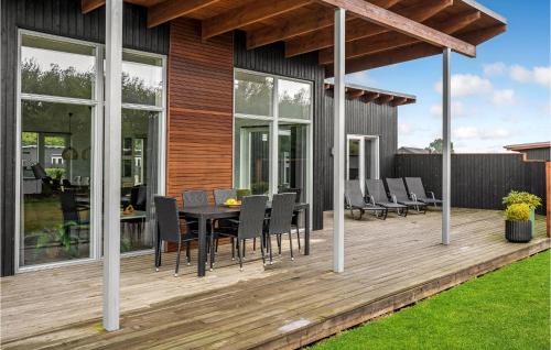 a wooden deck with a table and chairs on it at Four-Bedroom Holiday Home Haderslev With A Room Hot Tub 08 in Knud