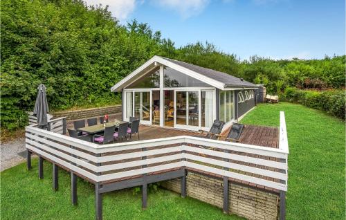 a large wooden deck with a table and chairs at Amazing Home In Broager With Kitchen in Broager