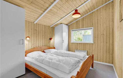 a bedroom with a large bed in a wooden wall at 4 Bedroom Beautiful Home In Blvand in Blåvand