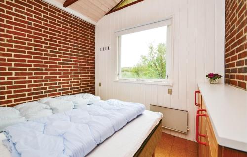 a large bed in a room with a brick wall at Holiday Home Lyngvej Fanø X in Fanø
