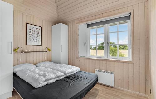 Cama en habitación con ventana en Nice Home In Haderslev With 3 Bedrooms And Wifi, en Årøsund