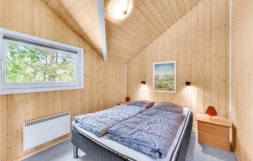 HemmetにあるAmazing Home In Tarm With 3 Bedrooms, Sauna And Wifiの木製の壁のベッドルーム1室
