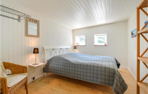 um quarto com uma cama e duas janelas em Coras Hytter em Fårevejle