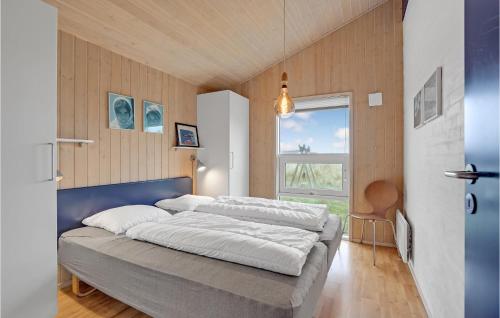 ヴィデ・サンデにあるCozy Home In Hvide Sande With House Sea Viewのベッドルーム1室(青いヘッドボード付きのベッド1台、窓付)