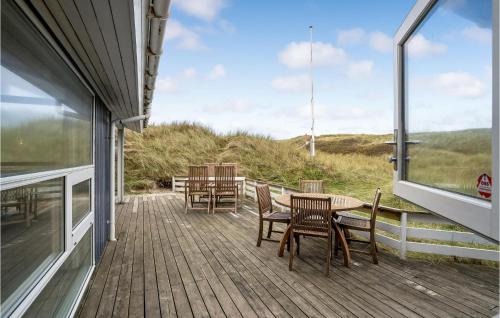 a wooden deck with chairs and a table on a house at Holiday Home Tingodden Hvide Sande Iv in Hvide Sande