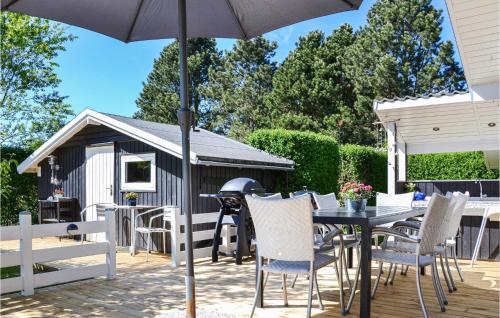 a patio with a table and chairs and an umbrella at Holiday Home Vibekesvej in Eskebjerg