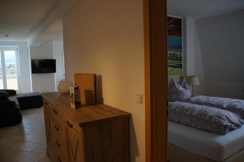 uma sala de estar com uma cama e uma cómoda num quarto em Ferienwohnung Castellberg em Heitersheim