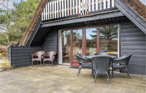 Un patio con sillas y una mesa en una casa. en Lovely Home In Rømø With Kitchen, en Tagholm