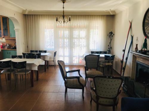 une salle à manger avec des tables, des chaises et une cheminée dans l'établissement Chalet 20 Min Far To Uludag Ski Resort, à Çekirge