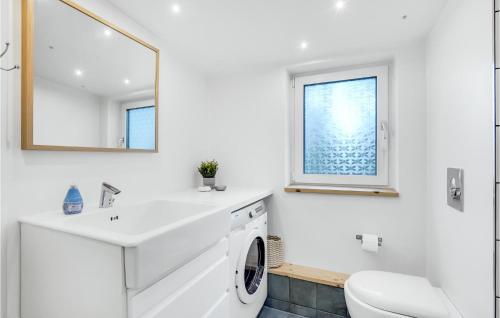 een witte badkamer met een wastafel en een wasmachine bij Gorgeous Home In Rm With Wifi in Rømø Kirkeby
