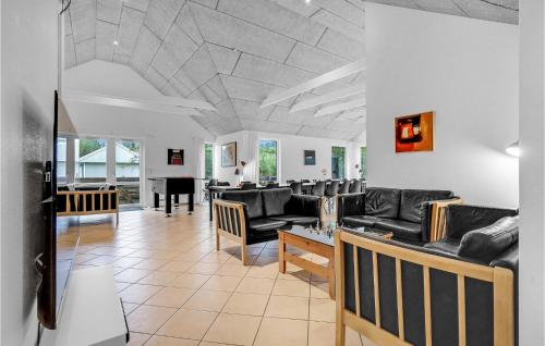 un soggiorno con divani neri e un pianoforte di Pet Friendly Home In Rømø With Kitchen a Rømø Kirkeby