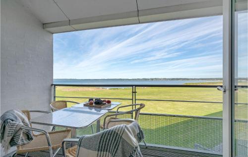 d'une table et de chaises sur un balcon avec vue sur l'océan. dans l'établissement 3 Bedroom Beautiful Apartment In Ebeltoft, à Ebeltoft