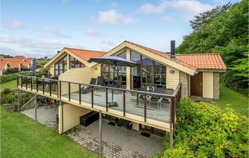 a house with a deck with an umbrella at Amazing Home In Egernsund With Sauna in Egernsund