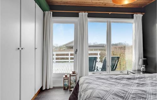 a bedroom with a bed and a large window at Stunning Home In Hejls With Sauna in Hejls