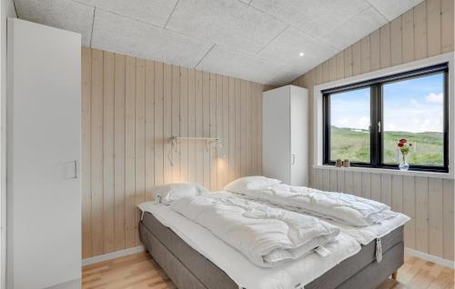 Bjerregårdにある3 Bedroom Awesome Home In Hvide Sandeの窓付きの客室の大型ベッド1台分です。