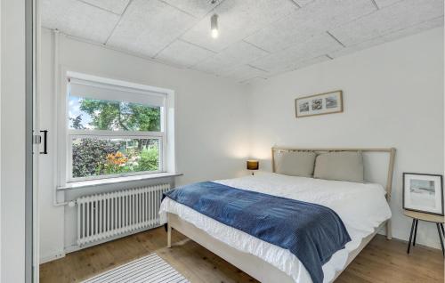 a white bedroom with a bed and a window at Nice Home In Billund With Wifi And 2 Bedrooms in Billund