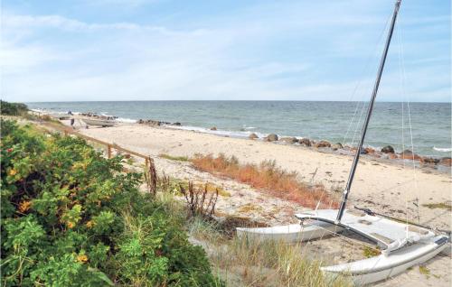 a sailboat sitting on a beach next to the ocean at Two-Bedroom Holiday Home In Otterup in Otterup