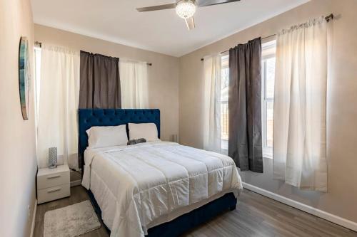 a bedroom with a blue bed and a window at Pretty Blue Bungalow in Carondelet