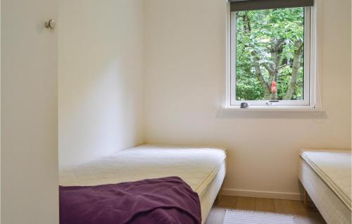 ジルレジェにある2 Bedroom Lovely Home In Gillelejeのベッド2台と窓が備わる小さな客室です。