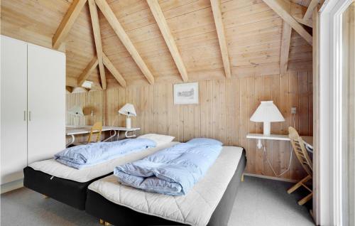 HavrvigにあるBeautiful Home In Hvide Sande With Sauna, Wifi And Indoor Swimming Poolの木製天井のドミトリールームのベッド2台分です。