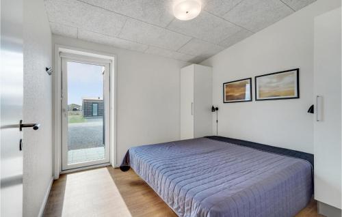 a bedroom with a bed and a large window at Gorgeous Home In Ringkbing With House A Panoramic View in Søndervig