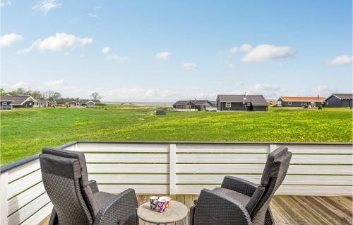 two chairs and a table on a deck with a field at Three-Bedroom Holiday Home Nordborg With A Room Hot Tub 01 in Nordborg