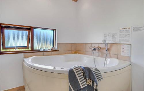 a bath tub in a bathroom with a window at Stunning Home In Ulfborg With 3 Bedrooms, Sauna And Wifi in Thorsminde
