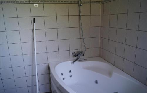 a white tub in a tiled bathroom at 2 Bedroom Beautiful Apartment In Middelfart in Middelfart