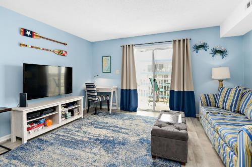 a living room with a couch and a tv at Marylander Condominiums, 90 steps from the beach in Ocean City