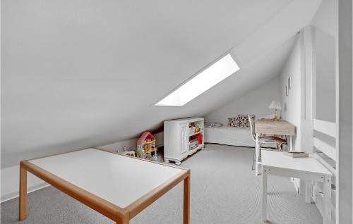 a attic room with a table and a bed at Holiday Home Rønnebærvænget Hejls V in Hejls