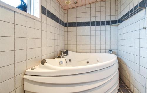 a bathroom with a white tub and a sink at Nice Home In Assens With House Sea View in Assens