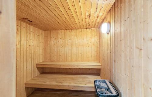 a wooden sauna with a bench in the middle at Amazing Home In Nexø With Sauna in Neksø