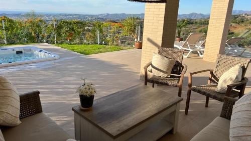 a patio with chairs and a table and a pool at Casa Carolina - This One in Higuerón with Quality and Peace in Mijas